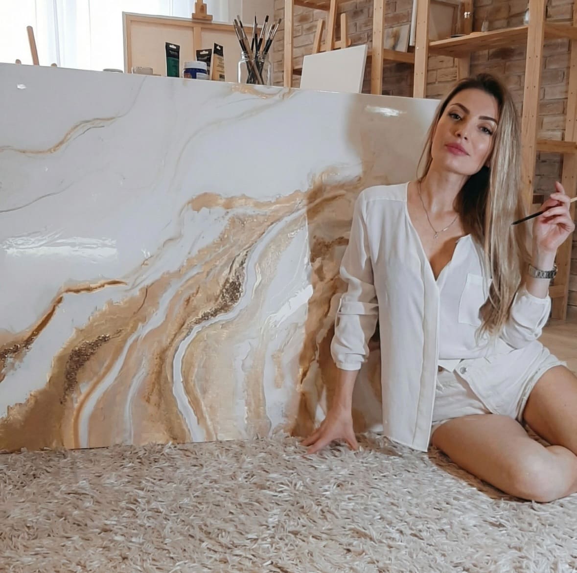 Irina Zadnipriana working on a textured canvas in her studio